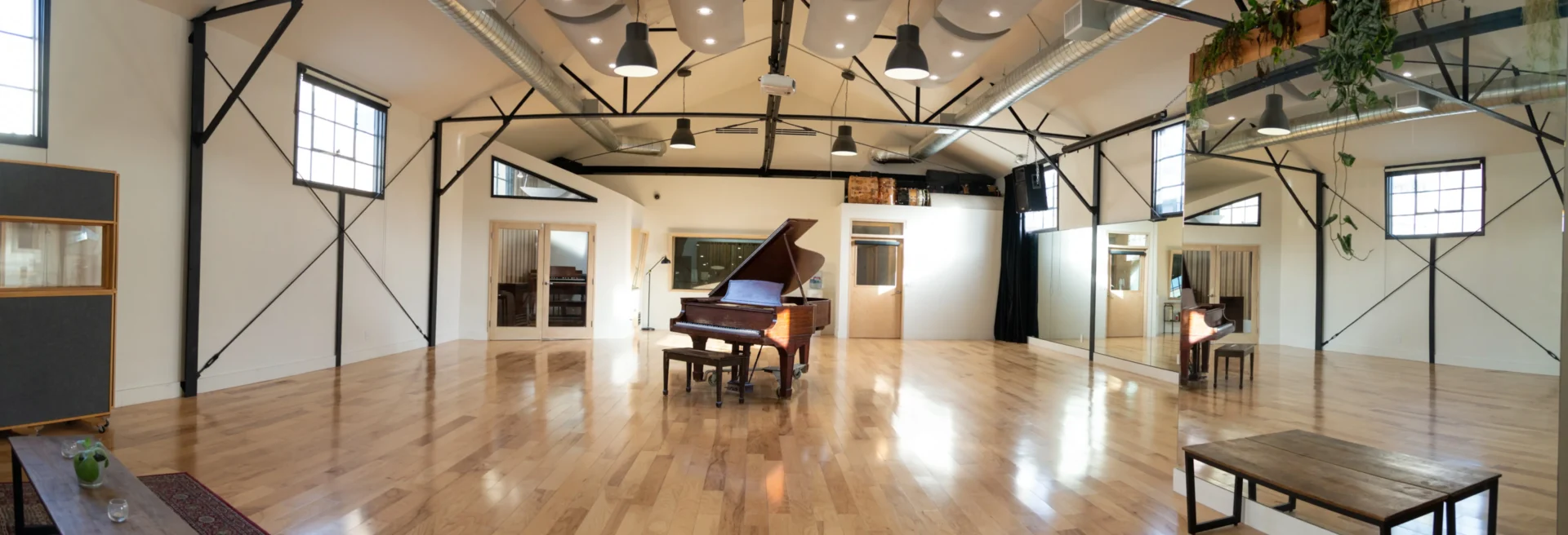 A piano in the middle of a room with wooden floors.